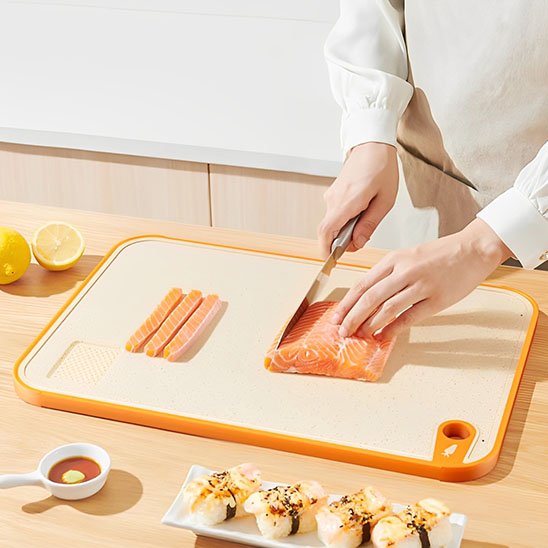 personne coupe saumon sur planche à découper 