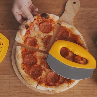 couteau à pizza dépose sur pizza sur planche