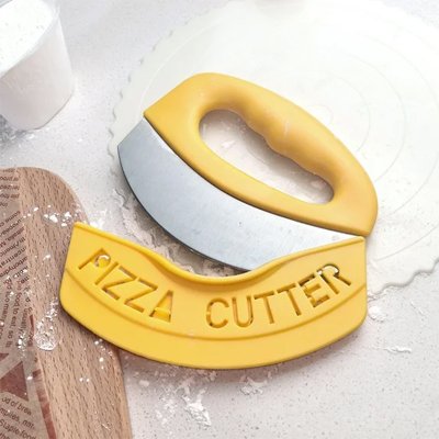 couteau à pizza lame arrondie dépose sur comptoir avec farine