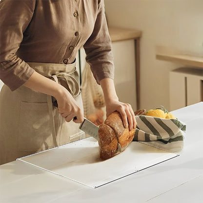 femme coupe un pain sur planche à découper transparente