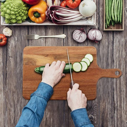 personne coupe concombre sur planche à découper bois
