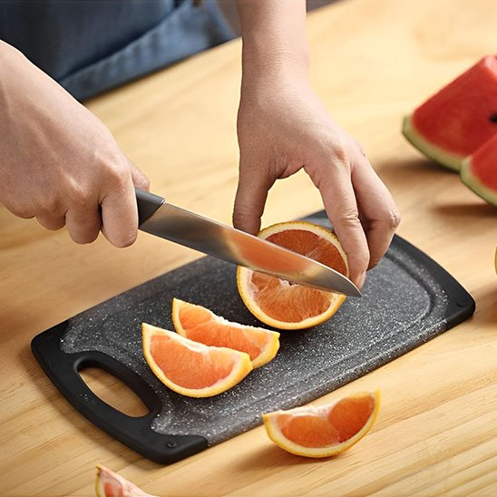 personne coupe orange sur planche a decouper grise