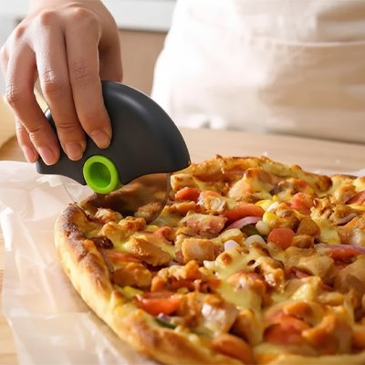 personne coupe pizza avec couteau a pizza vert