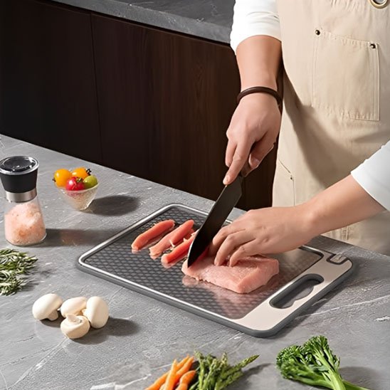 personne coupe poulet sur planche à découper en inox