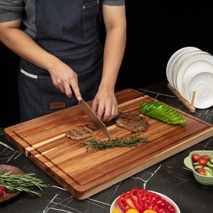 personne coupe viande sur planche à découper bois