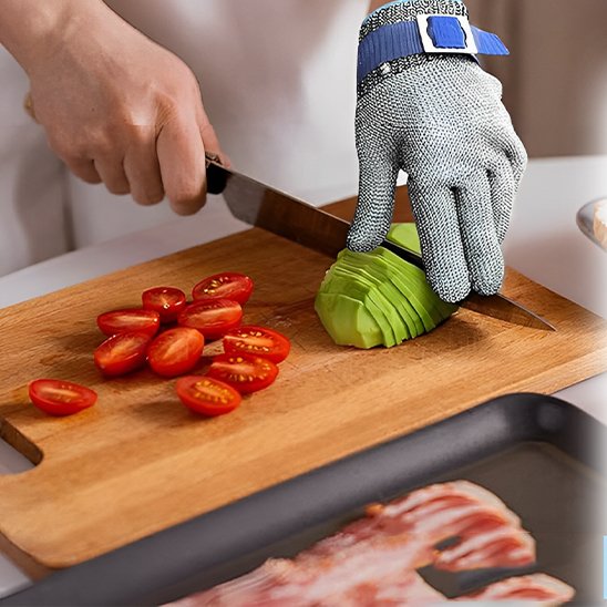 personne utilise gant anti coupure main gauche pour couper un avocat et tomates 
