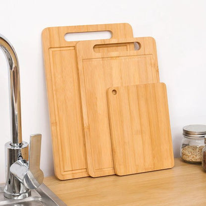 trois formats de planches à découper bois appuyées sur un mur
